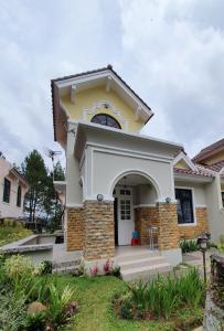 a house with a yellow and white at VILLA PANDA G Kota Bunga Puncak in Cinengangirang