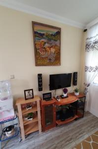 a living room with a flat screen tv and a table at VILLA PANDA G Kota Bunga Puncak in Cinengangirang