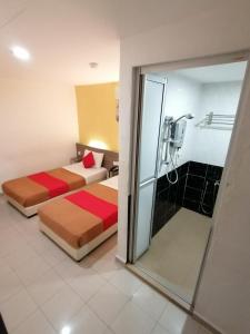 a hotel room with two beds and a shower at Yellow Mansion Hotel Melaka Raya in Melaka