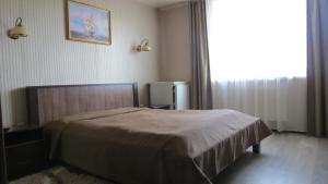 a bedroom with a bed and a large window at Apartments and Sauna in Truskavets