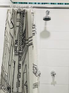 cortina de ducha con un dibujo de ciudad en Camino A La Villa Cucaita Hotel, en Cucaita
