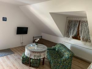 a living room with a table and a chair at Motel u Olka in Boczów