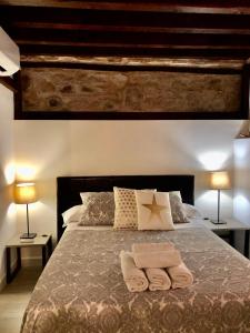 a bedroom with a bed with two towels on it at Apartamento San Pedro in Toledo