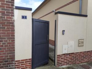 une porte bleue sur le côté du bâtiment dans l'établissement Studio chaleureux Beauvais-centre, gare et proche Aéroport, à Beauvais