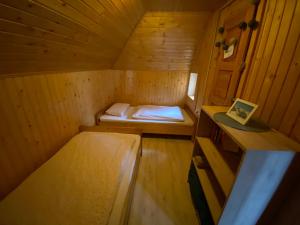 eine kleine Holzhütte mit einem Bett darin in der Unterkunft Chalet Košutnik Velika planina in Kamniška Bistrica