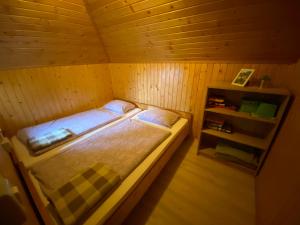 ein Schlafzimmer mit einem Bett in einem Holzzimmer in der Unterkunft Chalet Košutnik Velika planina in Kamniška Bistrica