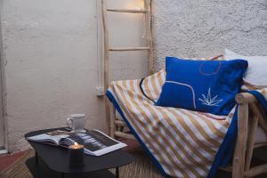 une chambre avec une chaise et une table avec un livre dans l'établissement Suites The Marcel, à Sète