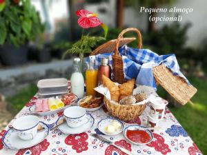 - une table de pique-nique avec de la nourriture et un panier de nourriture dans l'établissement Casa Velha D Fernando e Casa Avó Augusta, à Ribeira Brava