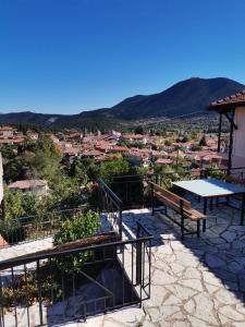 een tafel en banken op een patio met uitzicht bij Guesthouse Panorama in Vytina