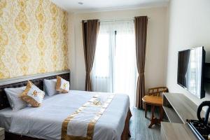 a bedroom with a large bed and a television at NH&Atilde; TRANG HOTEL in Cam Ranh