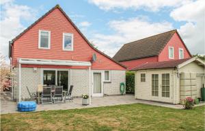 a house with a red roof and a patio at 4 Bedroom Gorgeous Home In Wemeldinge in Wemeldinge