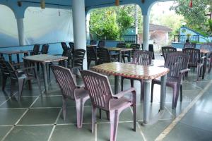 eine Gruppe von Tischen und Stühlen in einem Restaurant in der Unterkunft FATIMA'S PLACE in Vagator