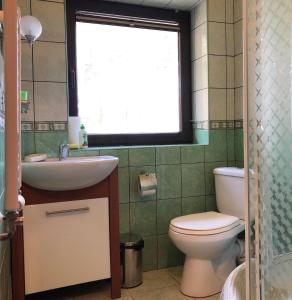 ポビエロボにあるGościnny Dworekのバスルーム(トイレ、洗面台付)、窓が備わります。