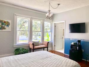 a bedroom with a bed and a tv and windows at Comfy and Spacious Suite with Free Parking in Miami
