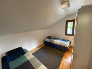 Habitación pequeña con 2 camas y ventana en Maison des Alpes accès station Les 2 Alpes 1h Grenoble en Vénosc