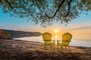 two yellow chairs sitting on a beach with the sunset at Boutique Suite #5 in Blue Mountains