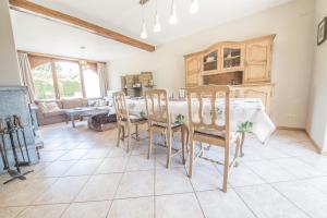 Una cocina y un comedor con mesa y sillas. en Le Longueville, en Durbuy