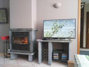 sala de estar con TV y chimenea en Le Longueville, en Durbuy