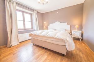 Un dormitorio con una cama grande y una ventana. en Le Longueville, en Durbuy