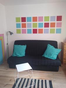 la Porte bleue في كابيستانج: غرفة معيشة مع أريكة سوداء وطاولة