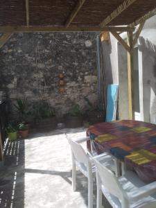 a patio with a table and chairs and a stone wall at la Porte bleue in Capestang
