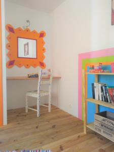 een kamer met een tafel, een stoel en een spiegel bij la Porte bleue in Capestang