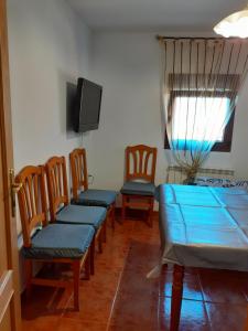 ラ・アルベルカにあるCastillo Altoの椅子、テーブル、テレビが備わる客室です。