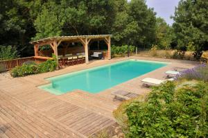 una piscina con terraza de madera y cenador en Jacuzzi, sauna, healthy food dans ancienne bergerie en Roquetaillade