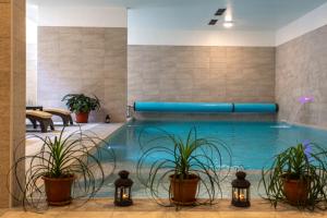 una piscina con plantas y luces en el vestíbulo del hotel en Hotel Manora, en Nerezine