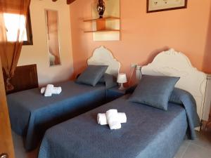 ラ・アルベルカにあるCastillo Altoのオレンジ色の壁の客室で、ツインベッド2台が備わります。