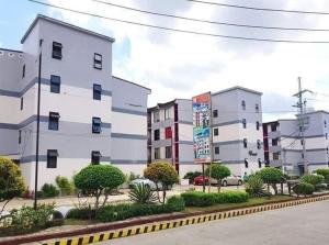 a row of white buildings in a parking lot at L & R Staycation in Imus