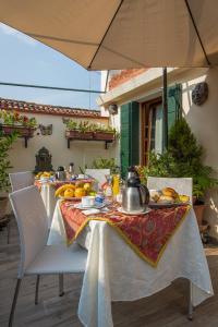 un tavolo con piatti di cibo sopra con un ombrello di Angeles Inn a Venezia