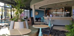 un restaurante con mesas, sillas y una barra en ibis Styles Le Treport Mers Les Bains en Mers-les-Bains