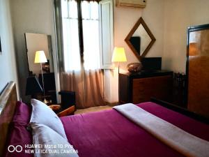 ローマにあるSuite 59 romeholidayhomeのベッドルーム1室(紫のシーツが敷かれたベッド1台、窓付)