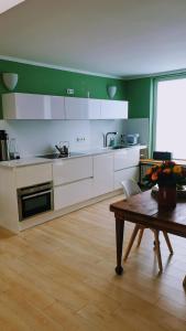 a kitchen with white cabinets and a wooden table at Bed and Pool in Oberursel