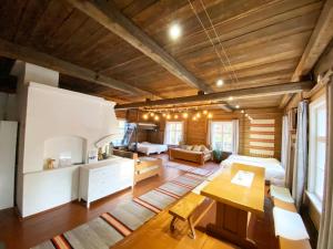 una sala de estar con techos de madera y una habitación con una mesa. en LAURI Historical Log House Manor en Rovaniemi