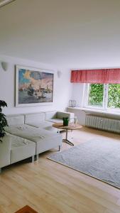 a white living room with a couch and a table at Bed and Pool in Oberursel