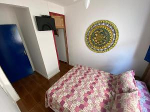 um quarto com uma cama e um prato na parede em Pousada Travessias em Tiradentes