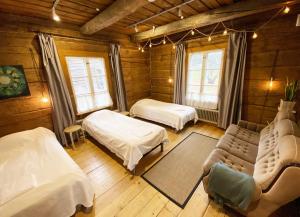 um quarto com duas camas e um sofá num quarto em LAURI Historical Log House Manor em Rovaniemi