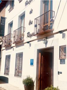 un edificio blanco con 2 balcones y una puerta en Alda Hospedería De Los Reyes, en Toledo