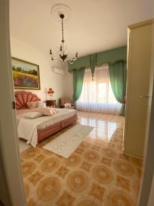 a bedroom with a bed and a chandelier at Le Fresie B&B in SantʼAntìoco