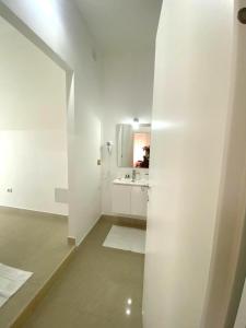 a white bathroom with a sink and a mirror at Le Fresie B&B in SantʼAntìoco