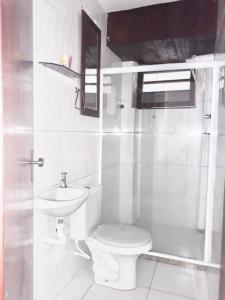 uma casa de banho branca com um WC e um lavatório em Hostel Meu Sossego Vilas em Lauro de Freitas