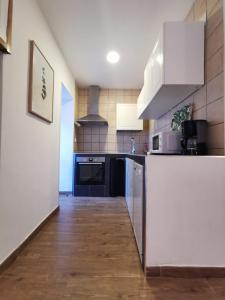 a kitchen with white appliances and a wooden floor at solaz del ambroz-Hervas in Hervás