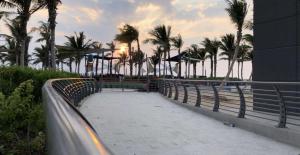 een loopbrug bij het strand met palmbomen bij Luxury villas for rent in Jeddah