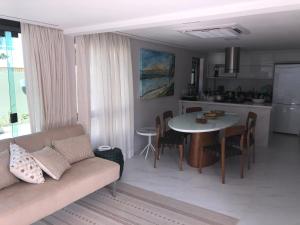 a living room with a couch and a table at Muro Alto Residence in Porto De Galinhas