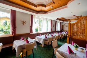 una fila de mesas en un restaurante con servilletas rojas en Hotel Marlingerhof, en Marlengo