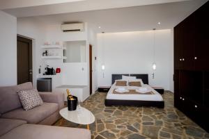 a bedroom with a bed and a couch at Sea Shell Beach Suite in Laganas