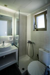 a bathroom with a shower and a toilet and a sink at Sea Shell Beach Suite in Laganas