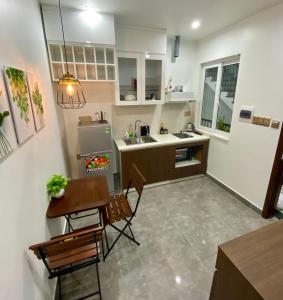 a small kitchen with a table and chairs and a sink at Khánh Phong Apartment in Waterfront in Hai Phong